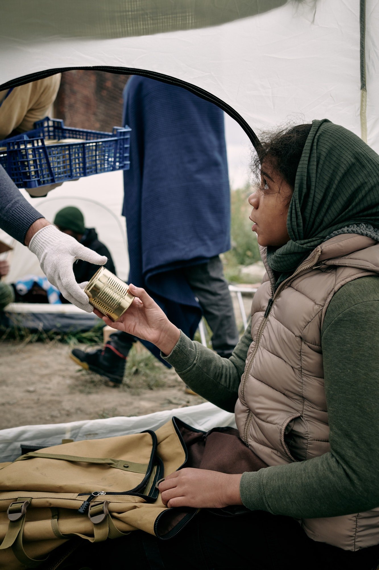 hungry-girl-refugee-taking-tinned-food-from-gloved-hand-of-volunteer.jpg